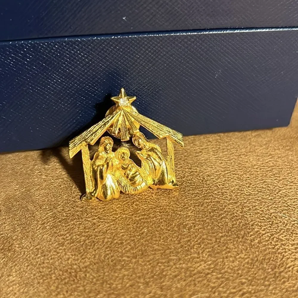 Live nativity gold brooch.